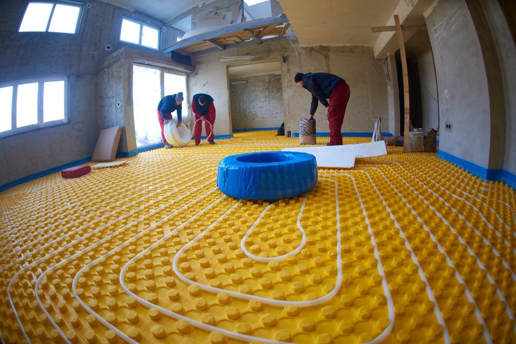 Trabajadores instalando suelo radiante en una casa